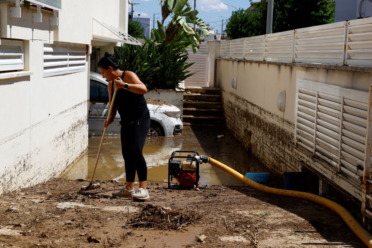 Κάτοικος καθαρίζει την είσοδο του γκαράζ της μετά την υπερχείλιση του ποταμού Φουά