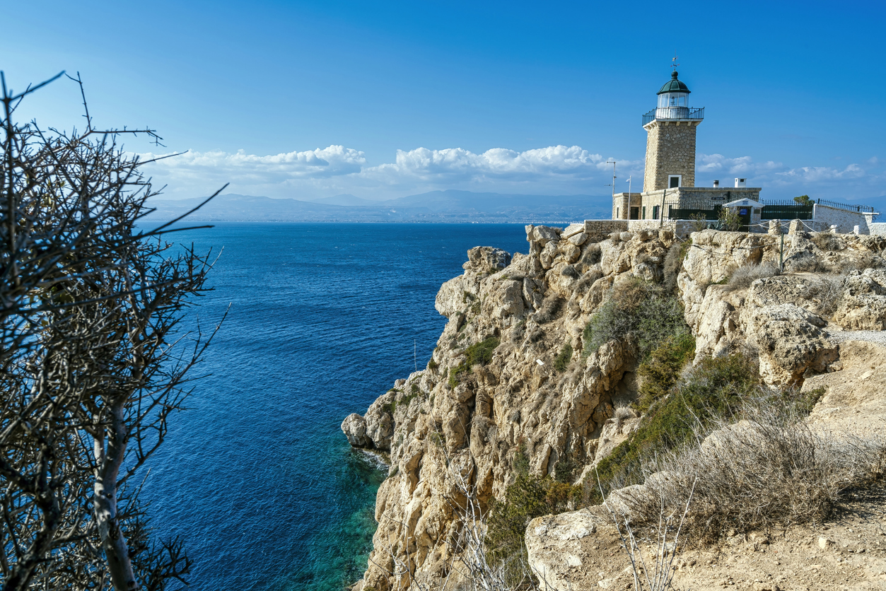 Lighthouse Melagavi, also known as Heraion Lighthouse, stands on a rugged cliff above the Corinthian Gulf in Loutraki, Greece, with breathtaking coastal views.