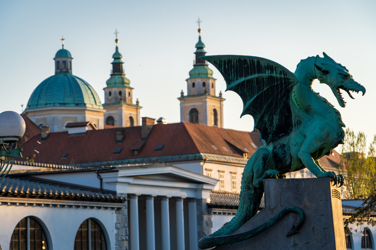 Beautiful dragon statue on the Dragon Bridge in Ljubljana, Slovenia. Beautiful postcard of Ljubljana, Slovenia. View of Ljubljana from the Dragon Bridge